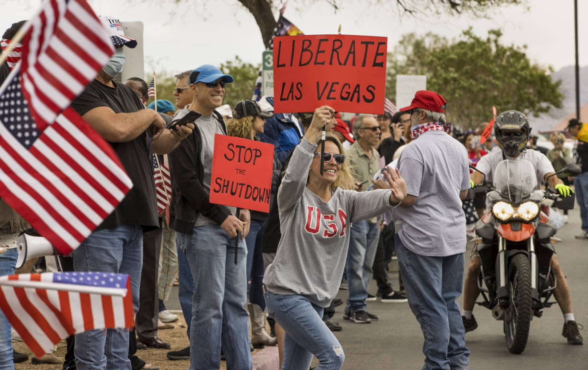Protester Lauren Robison welcomes others arriving to the Reopen Nevada protest at the Grant Sa ...