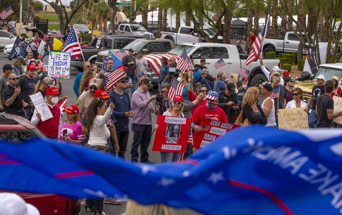 Protesters chant and welcome others arriving to the Reopen Nevada protest at the Grant Sawyer S ...