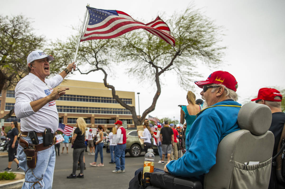 Protesters Scott Bockert, left, and Craig Schmidt talk politics during the Reopen Nevada protes ...