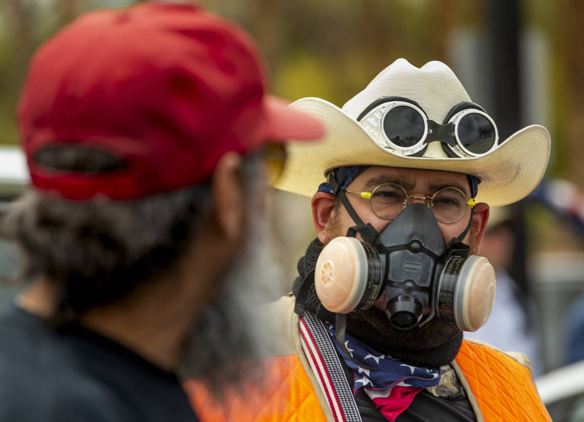 Giles Smith, right, wears a mask while joining many others during the Reopen Nevada protest at ...
