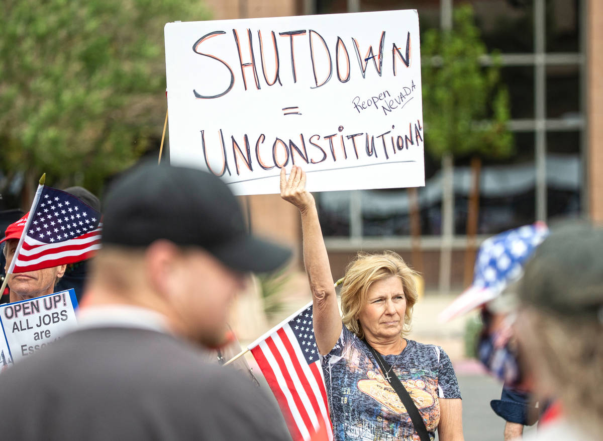 Sue Thiel, middle, takes part in a protest outside the Grant Sawyer State Office Building organ ...