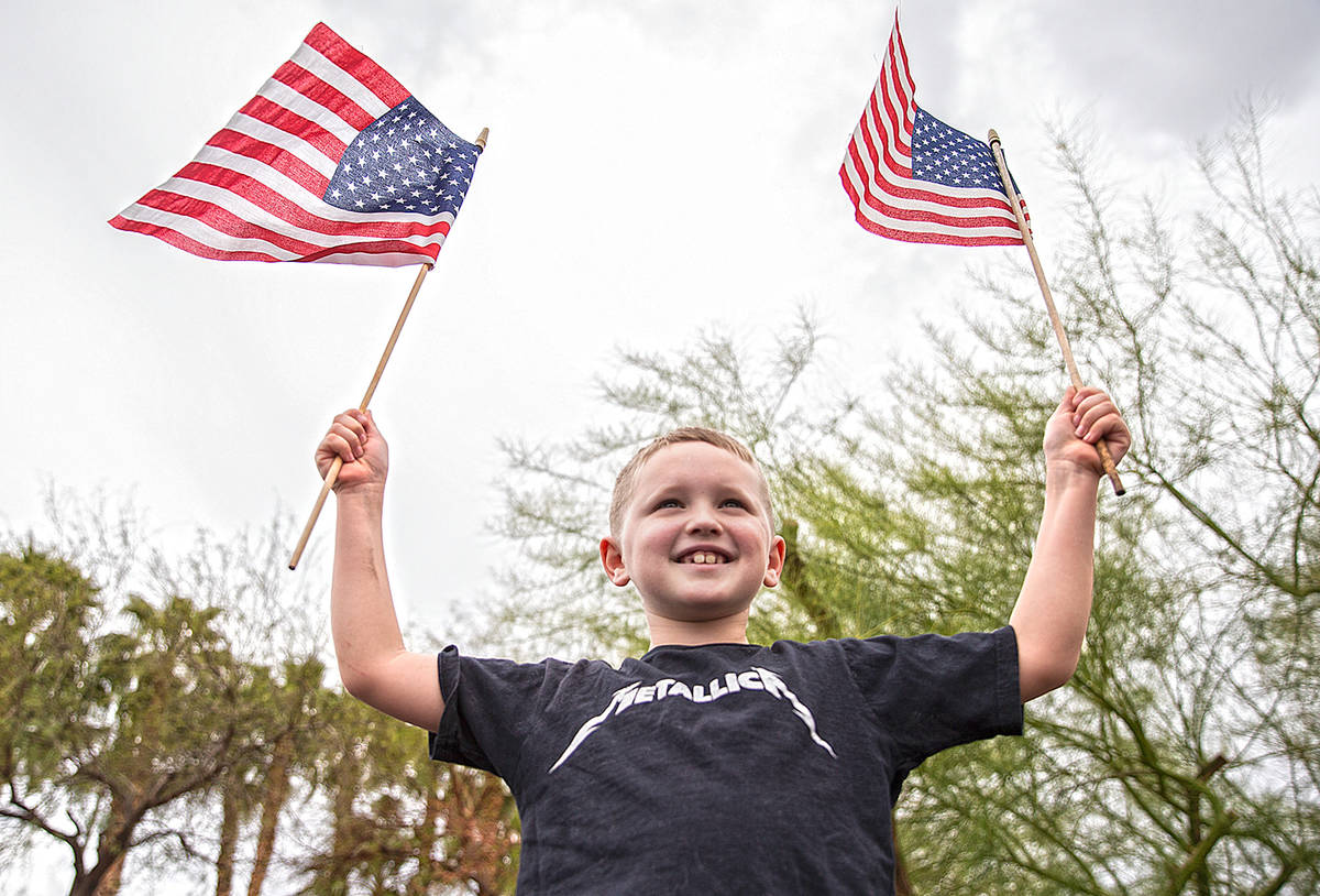 Jackson Hrustyk, 8, waves American flags during an event organized by Reopen Nevada at the Gran ...