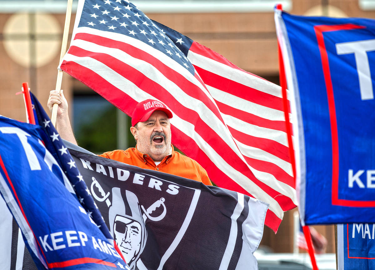 Dave Moreno waves an American flag during an event organized by Reopen Nevada at the Grant Sawy ...