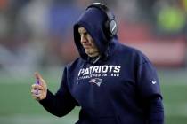 New England Patriots head coach Bill Belichick gives a signal to the team from the sideline in ...