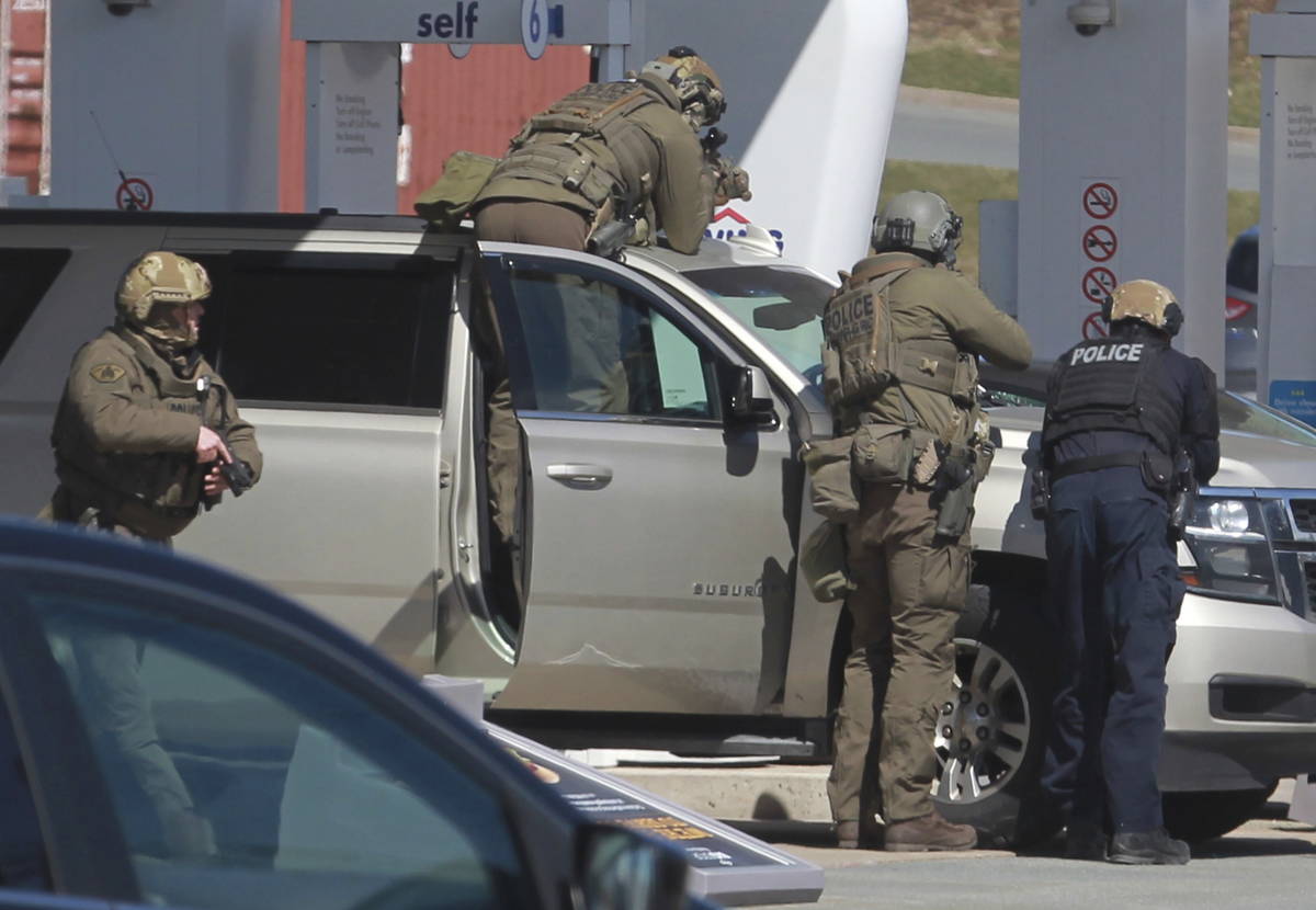Royal Canadian Mounted Police officers prepare to take a suspect into custody at a gas station ...