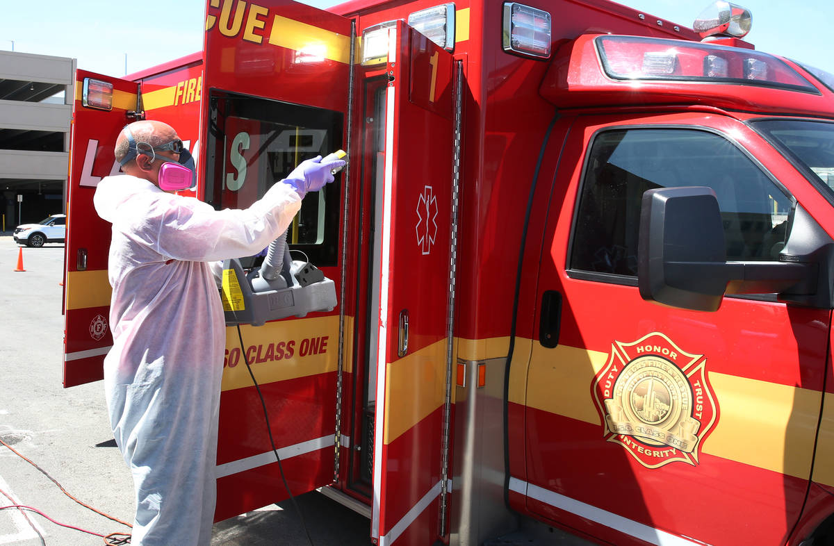 Bill Meeks of Summit Restoration disinfects a Las Vegas Fire Department Paramedic truck on Mond ...