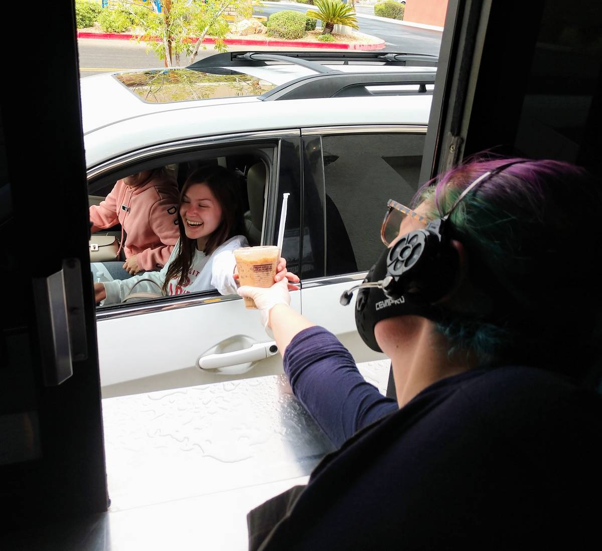 A Coffee Bean & Tea Leaf member hands a drink to a drive-thru customer. (Coffee Bean & Tea Leaf)