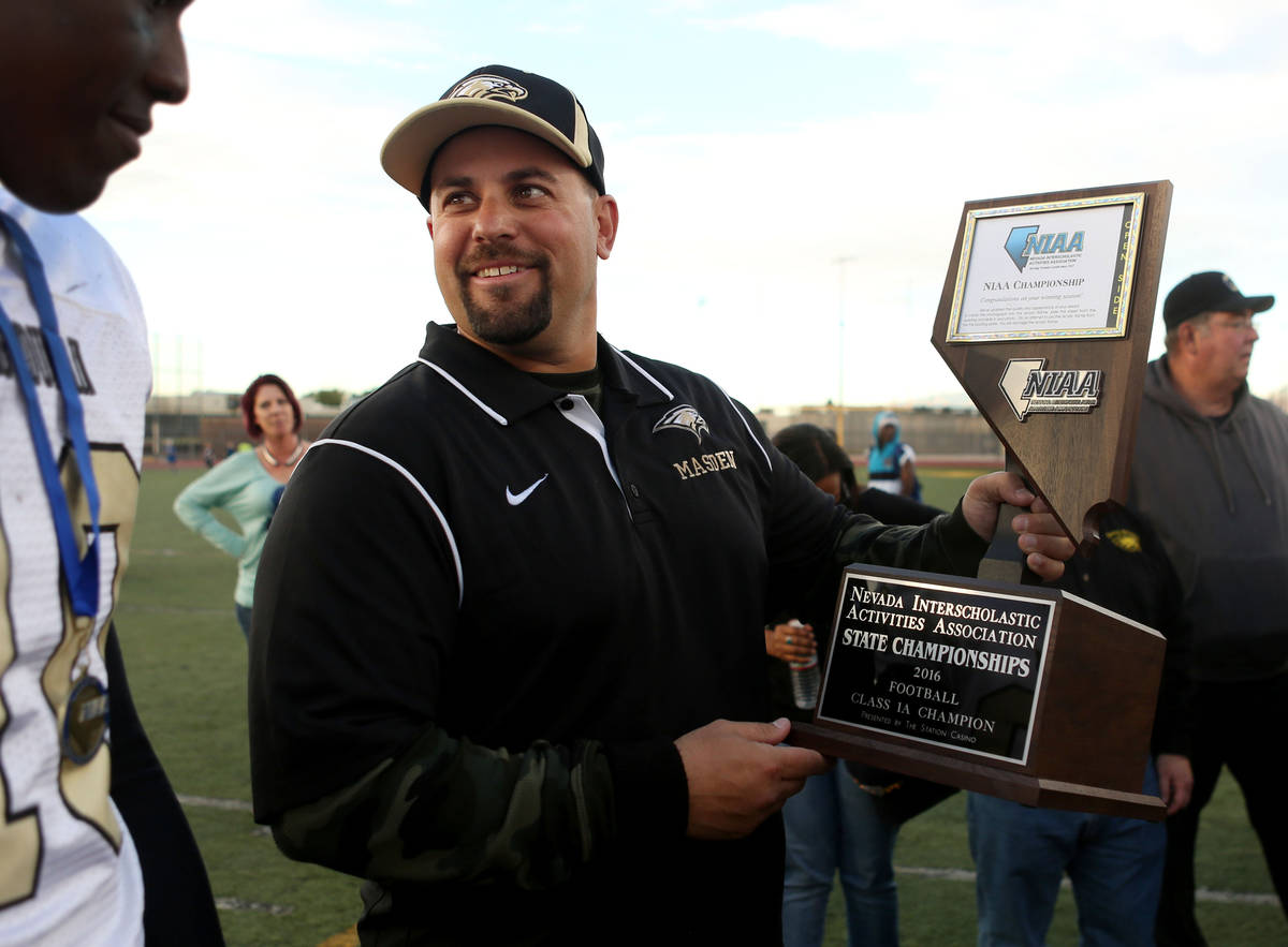 Spring Mountain's Head Coach Aaron Masden holds his team's trophy after winning the class 1A st ...