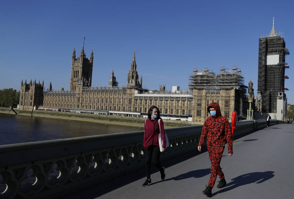 People wear masks as they walk near Britain's Houses of Parliament as the country is in lockdow ...