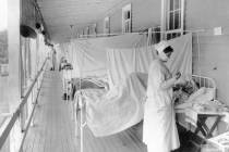In this November 1918 photo made available by the Library of Congress, a nurse takes the pulse ...