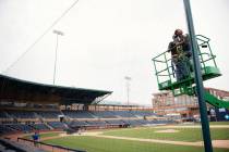 Elias Ruiz, front right, and Steven Woytysiak, both from C&H Baseball, help install a 35-foot-h ...