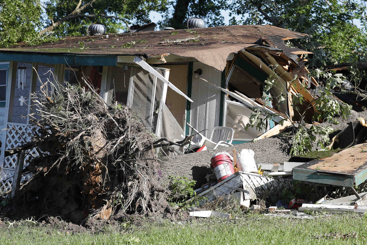 A large tree is uprooted in front of a destroyed home, Thursday, April 23, 2020, in Onalaska, T ...