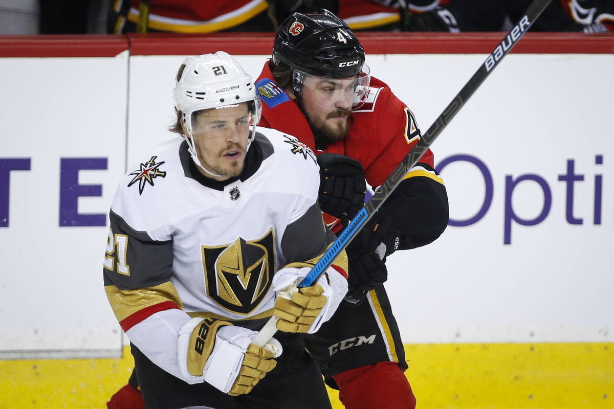 Vegas Golden Knights' Nick Cousins, left, gets past Calgary Flames' Rasmus Andersson during fir ...