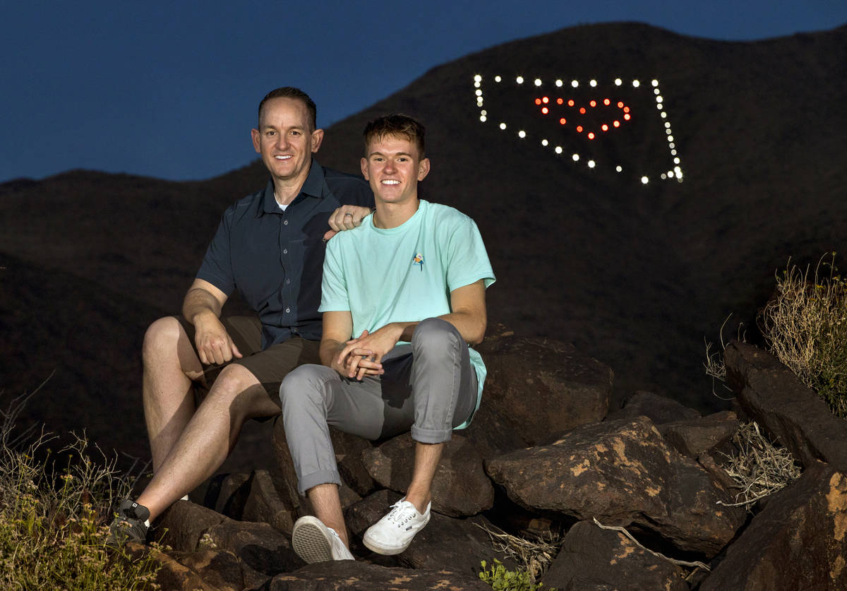 David Koch, left, and son Mason sit on rocks at the trail head below their Nevada light display ...
