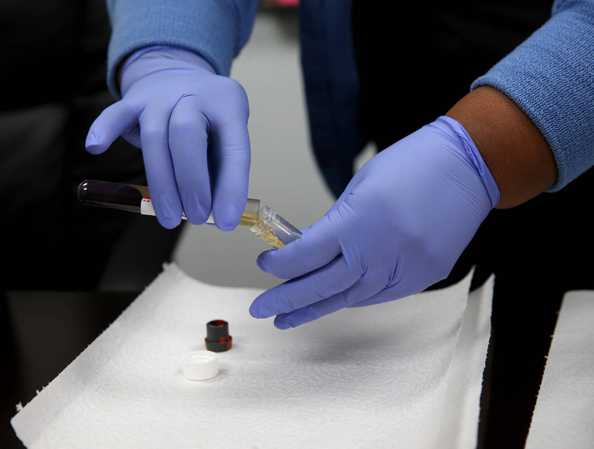 Phlebotomist Dana Duncan, 37, separates serum from blood during voluntary employee COVID-19 ant ...