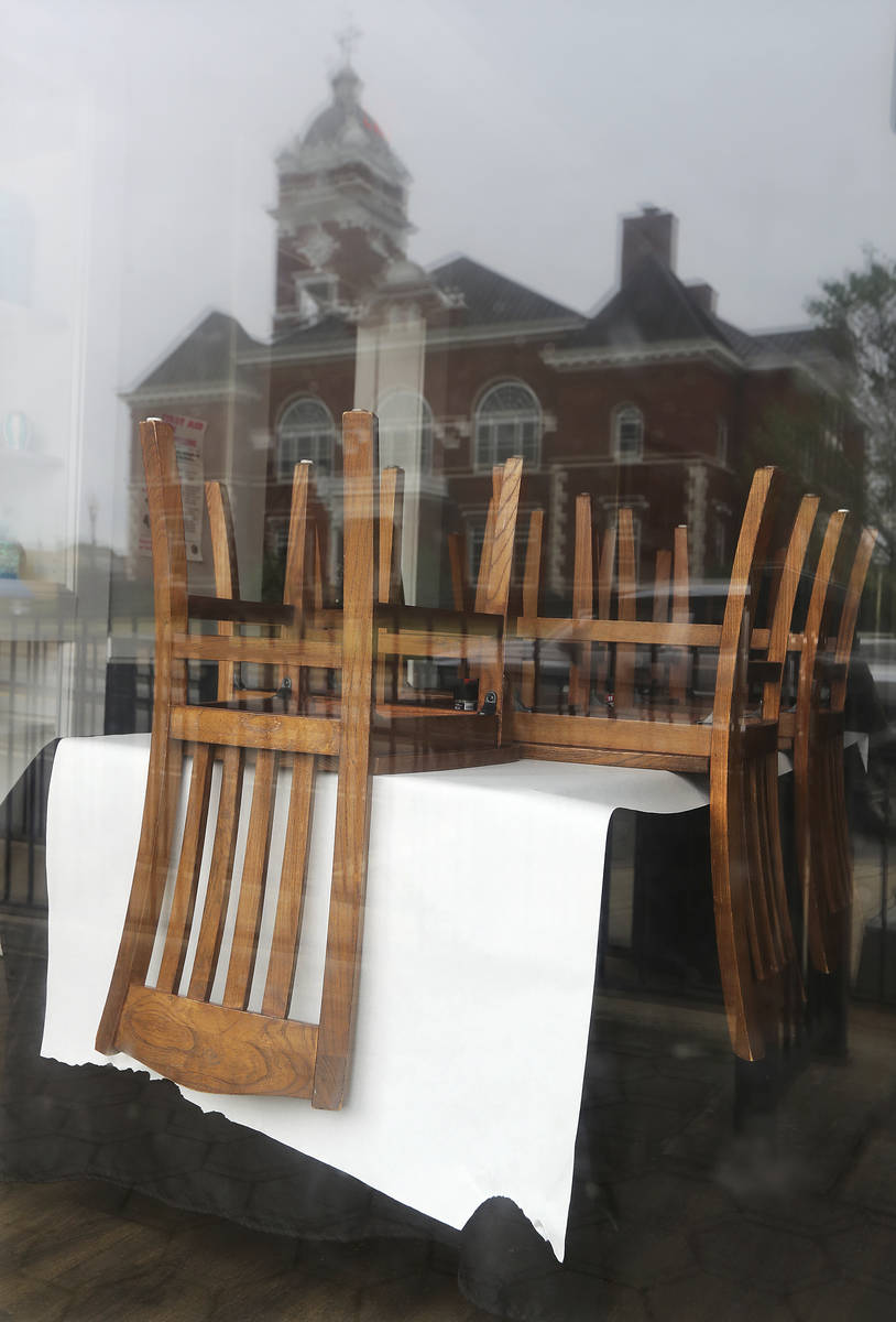 Chairs are stacked on top of tables, seen through the front windows of Minori's Italian Ristora ...