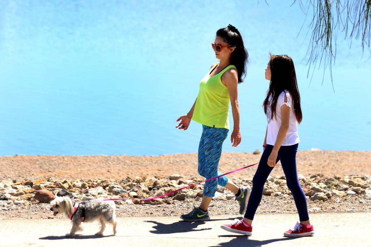 People walk with their dog at at Cornerstone Park on Wednesday, April 22, 2020, in Henderson. ( ...