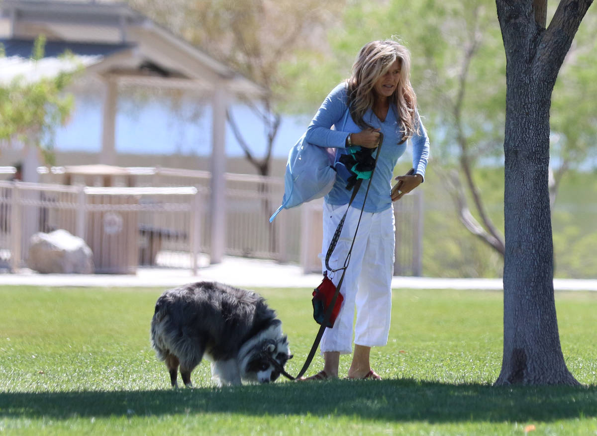 A woman walks her dog at Cornerstone Park on Wednesday, April 22, 2020, in Henderson. (Bizuayeh ...