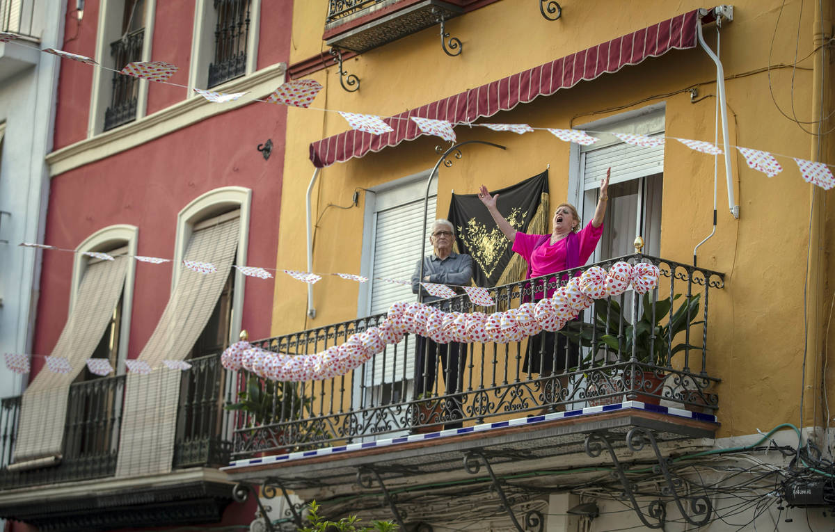 In this photo taken on Saturday April 25, 2020, a woman sings on her decorated balcony during t ...