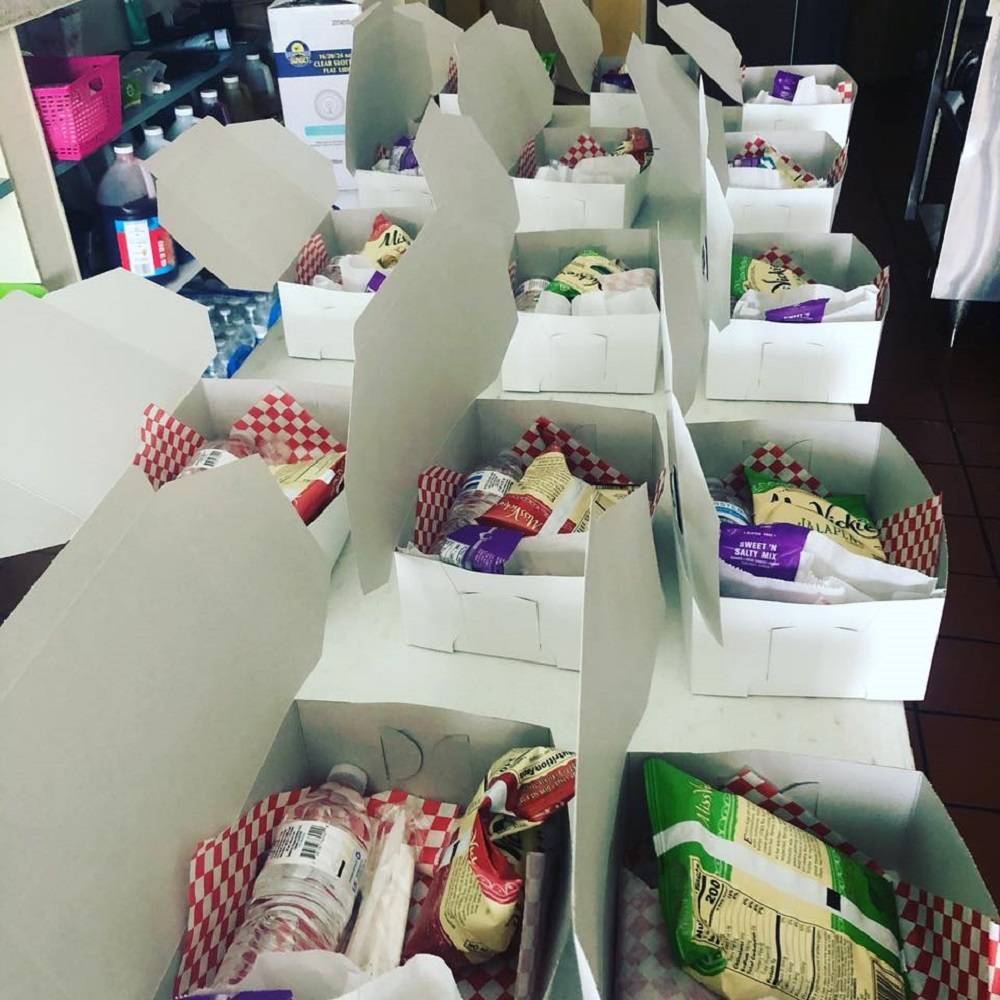 Donated lunch boxes to be delivered to health care workers are prepared at Beach Cafe, 7750 S. ...
