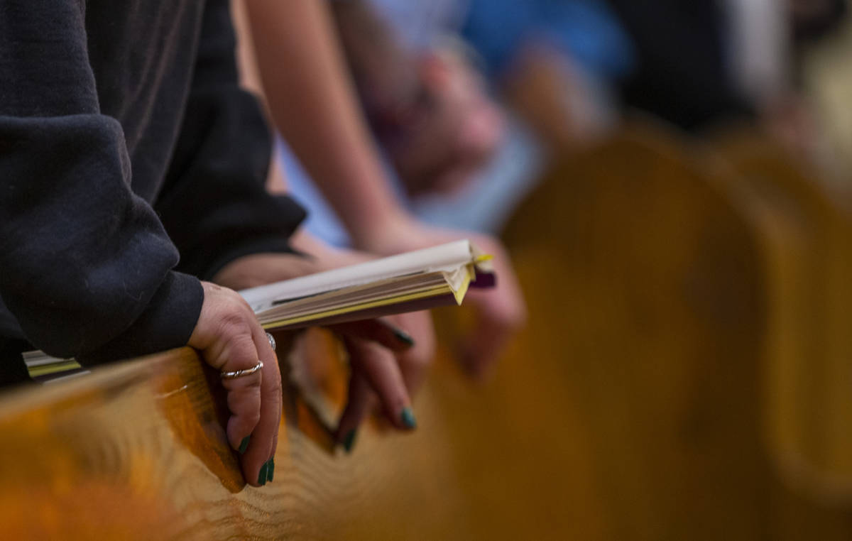 Parishioners pray during Sunday Mass at St. Anne's Catholic Church where they were asked to use ...