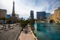 People pass by the Bellagio while walking the Las Vegas Strip on Thursday, April 16, 2020. (Cha ...