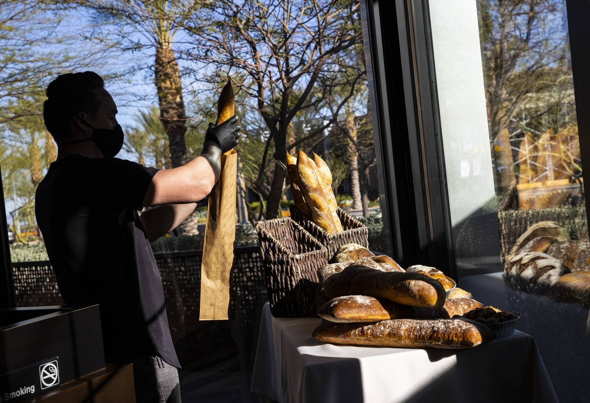 Doug Chippewa, senior beverage manager at Wolfgang Puck Fine Dining Group, grabs a loaf of brea ...