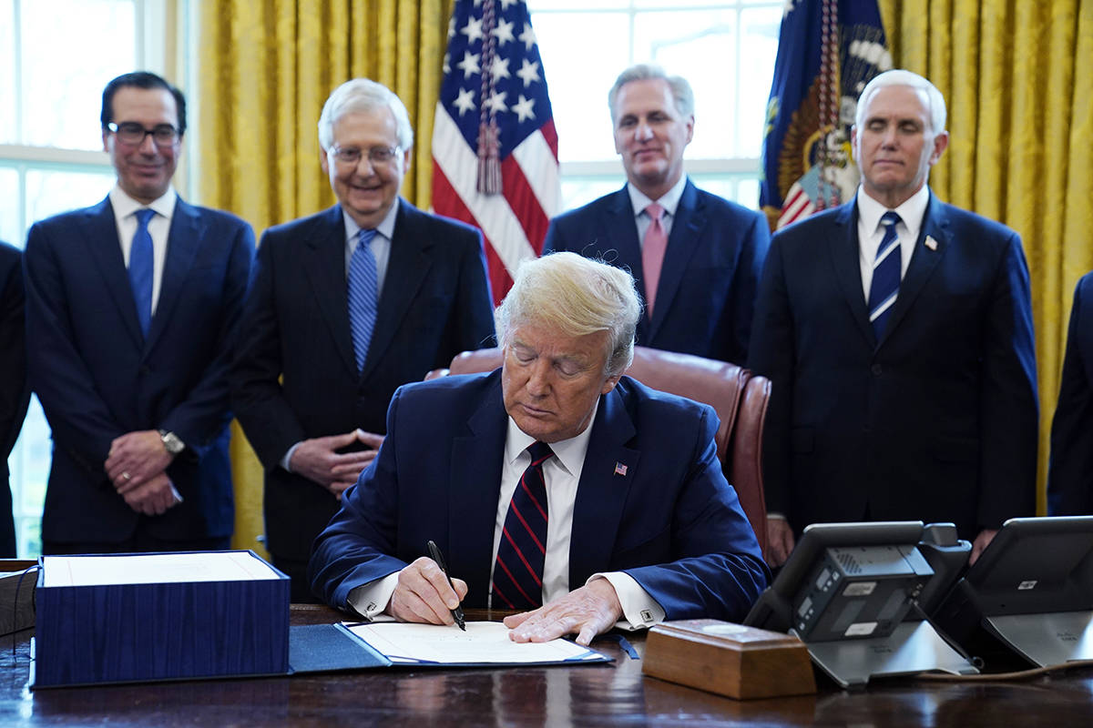 President Donald Trump signs the coronavirus stimulus relief package, at the White House in Was ...