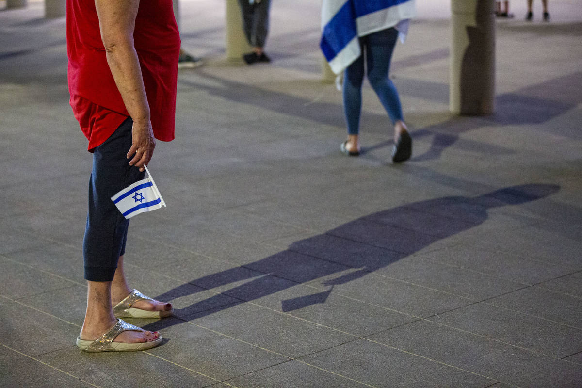 An attendee holds the Israeli flag while practicing social distancing as Gal Hayon, not picture ...