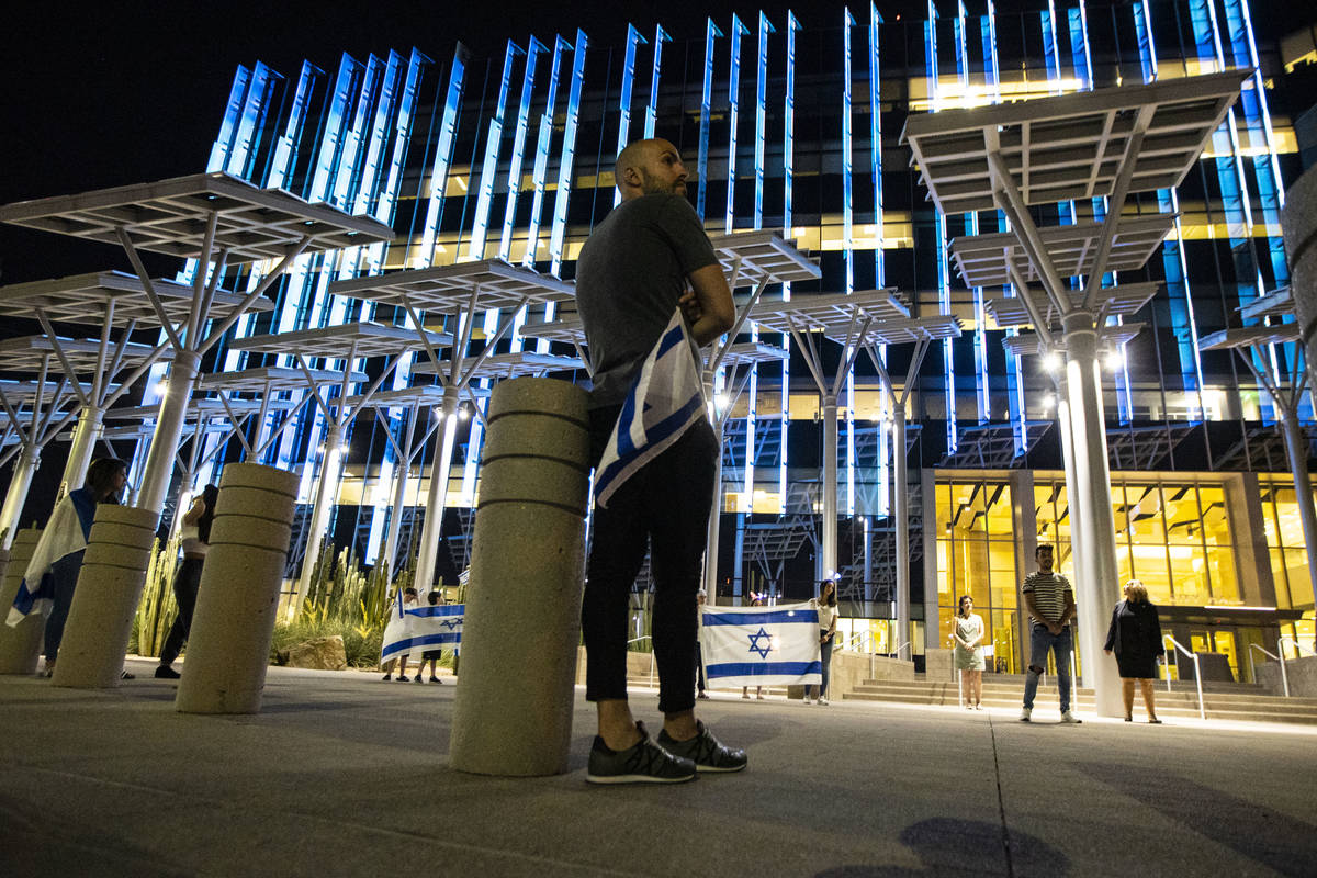 A man holds the flag of Israel as it is displayed at Las Vegas City Hall in honor of Israel's 7 ...