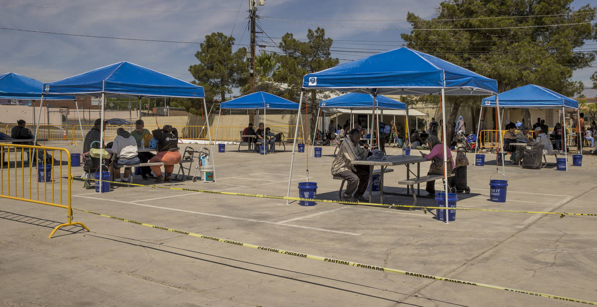 Clients sit under newly installed shaded tables within the Courtyard Homeless Resource Center a ...