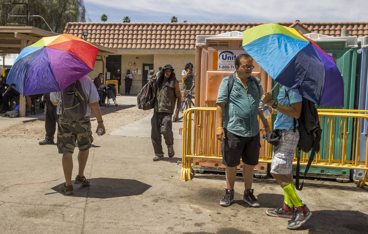 Clients carry colorful umbrellas within the Courtyard Homeless Resource Center as temperatures ...