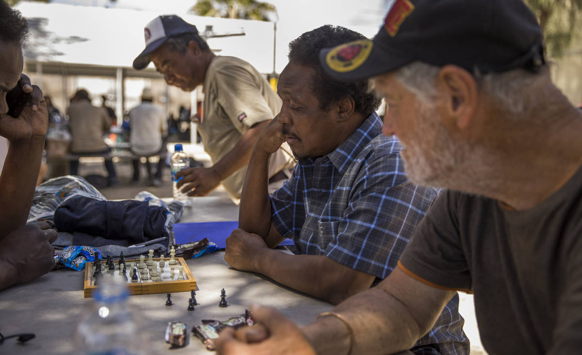 Client Brick Houston, center, plays some chess in the shade within the Courtyard Homeless Resou ...