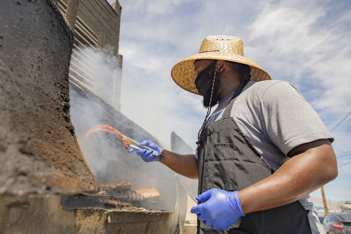 Annie's Kitchen pit master Quincy Reynolds, prepares ribs for to-go orders at the restaurant th ...