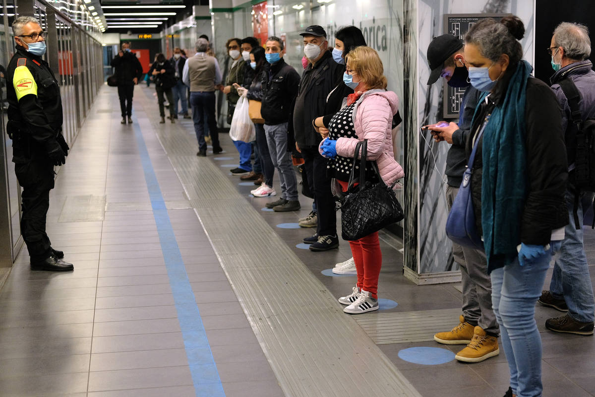 People stand apart from each other as they wait for a subway train in Rome, Monday, April 27, 2 ...