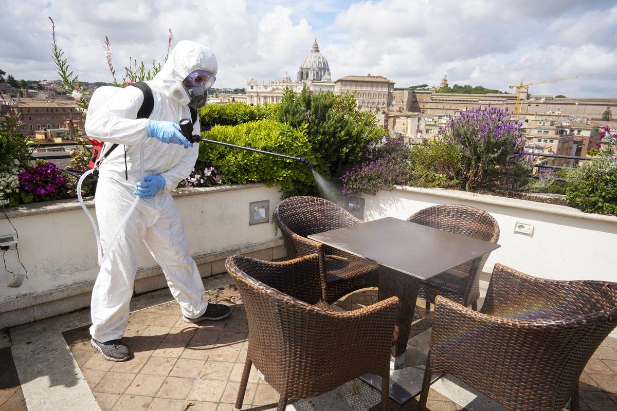 A worker disinfects the roof terrace of the Atlantic hotel, in Rome, Wednesday, April 29, 2020. ...