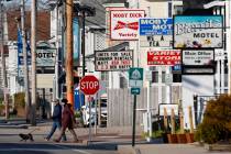 A couple walks by a row of closed motels, Wednesday, April 29, 2020, in Old Orchard Beach, Main ...