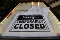 FILE - In this April 28, 2020 file photo, a closed sign is posted at a restaurant along the Riv ...