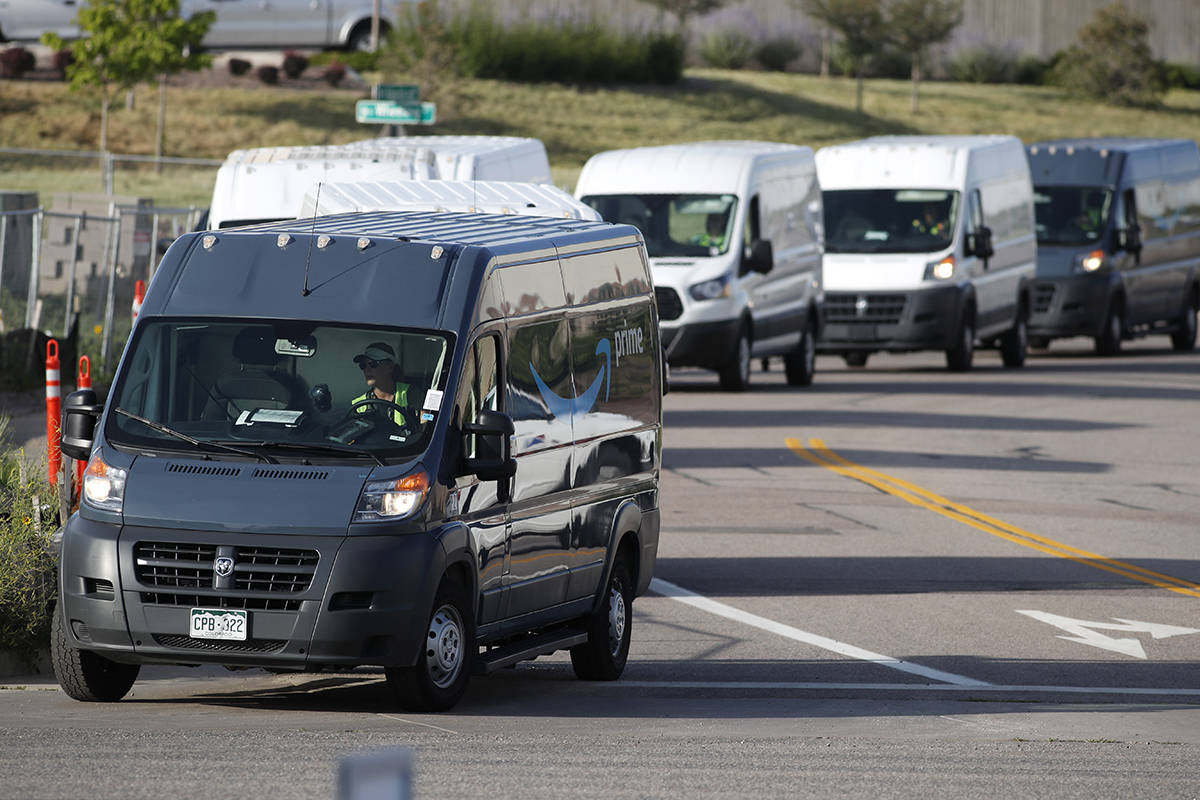 In this Tuesday, July 30, 2019, file photograph, vans queue up to leave an Amazon delivery cent ...