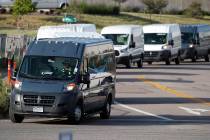 In this Tuesday, July 30, 2019, file photograph, vans queue up to leave an Amazon delivery cent ...