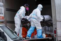 Workers move bodies to a refrigerated truck from the Andrew T. Cleckley Funeral Home in the Bro ...