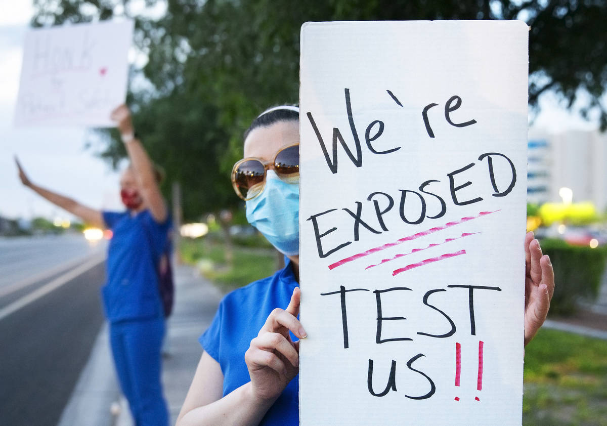 Intensive care nurse Nasim Akbari holds a sign advocating for better protection, testing and be ...