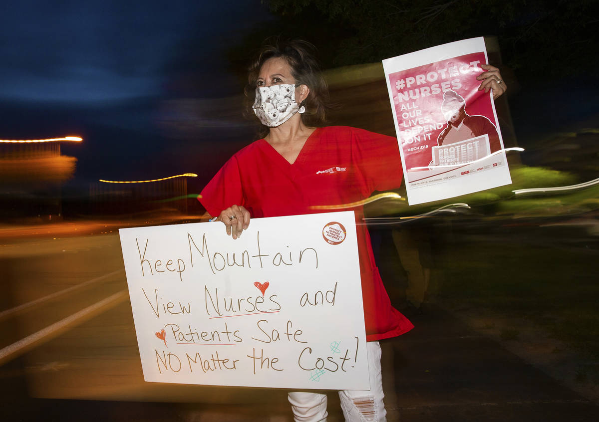 Critical care nurse Marian Madsen holds a sign advocating for better protection, testing and be ...