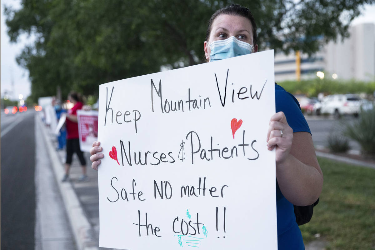 Emergency room nurse Nicole Harms holds a sign advocating for better protection, testing and be ...