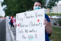 Emergency room nurse Nicole Harms holds a sign advocating for better protection, testing and be ...