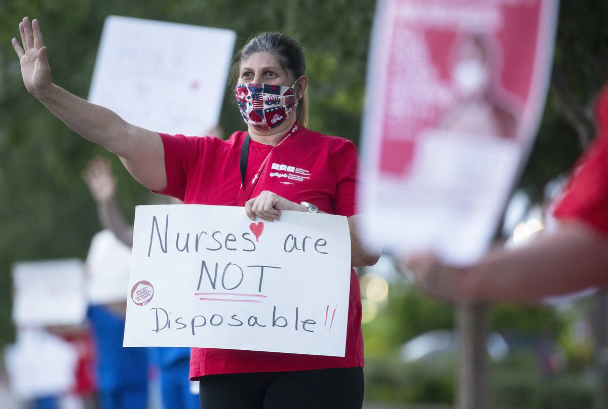 Recovery room nurse Lauren Elfman holds a sign advocating for better protection, testing and be ...