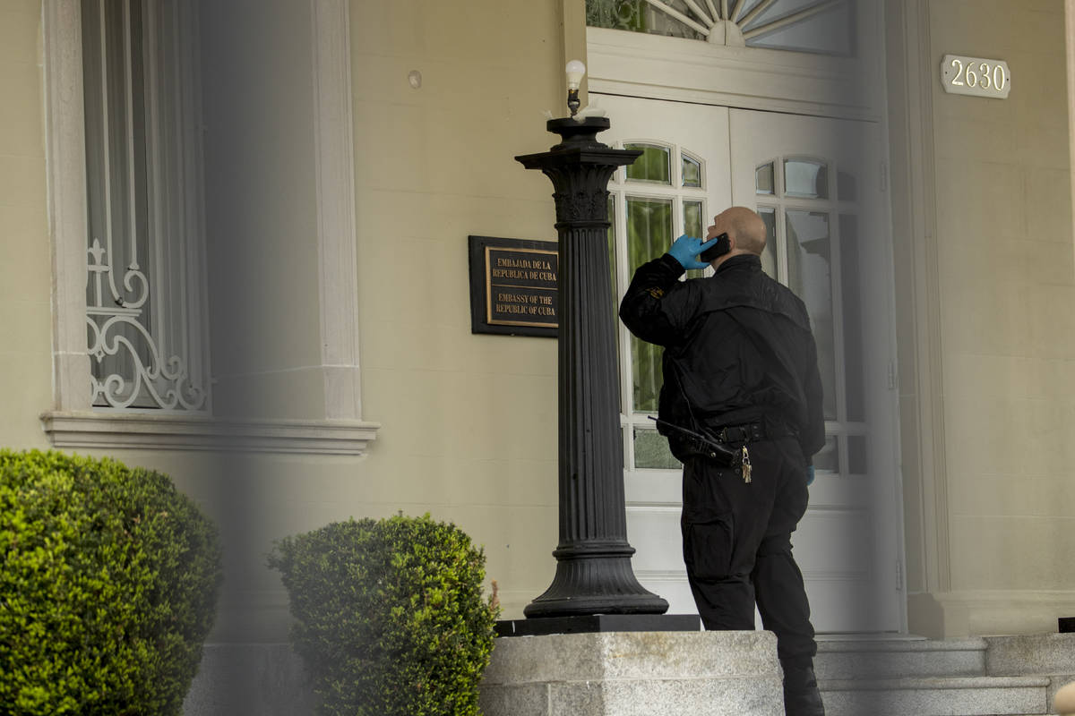 A Secret Service officer looks at a bullet hole after police say a person with an assault rifle ...