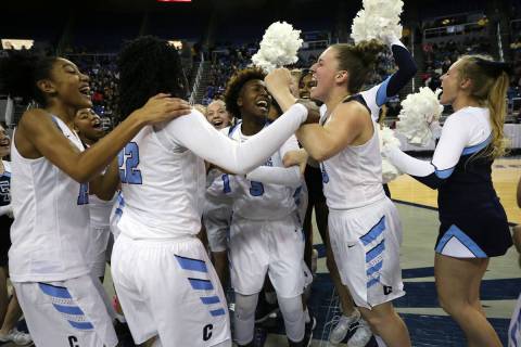 The Centennial Bulldogs celebrate a 74-65 overtime win over Liberty for the NIAA state basketba ...