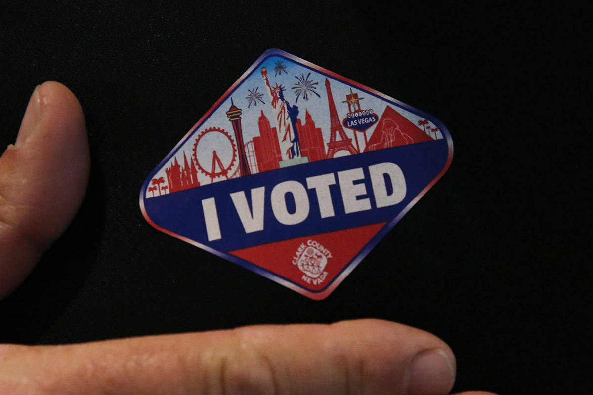 Kirk Rossmann shows off his "I Voted" sticker after casting his ballots at a polling station at ...