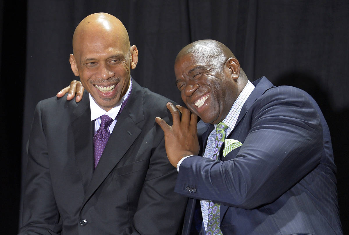 Former Los Angeles Laker Earvin "Magic" Johnson, right, hugs former teammate Kareem A ...